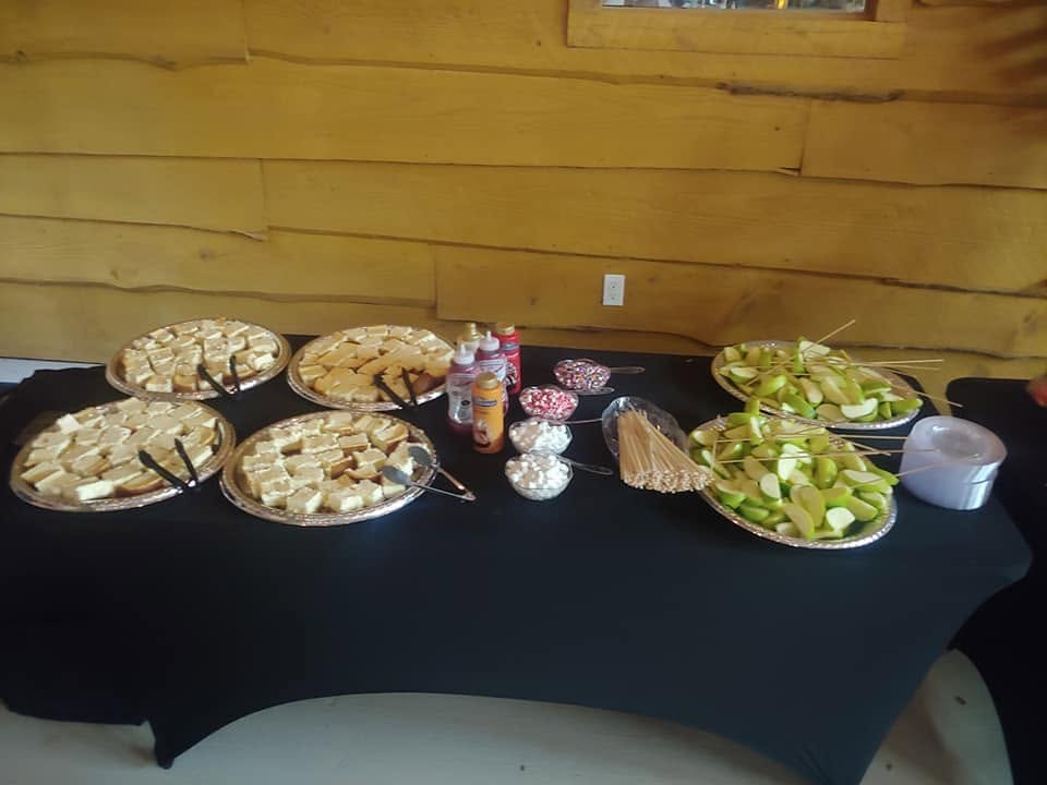 Dessert table with cheesecake bites, sliced apples, and toppings