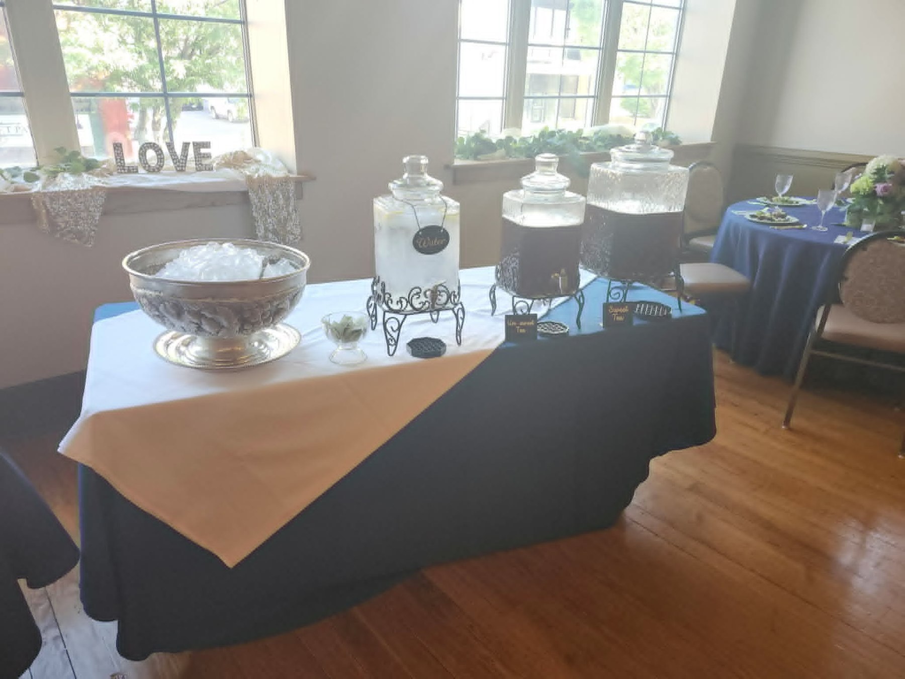 Event beverage station with glass dispensers on a blue and white table