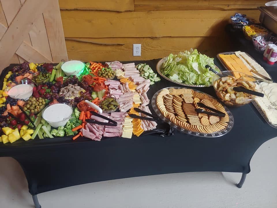 Large charcuterie and grazing buffet with meats, cheeses, fruits, vegetables, and crackers