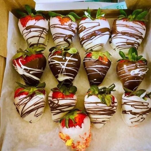 Chocolate-covered strawberries in white and milk chocolate with decorative drizzle