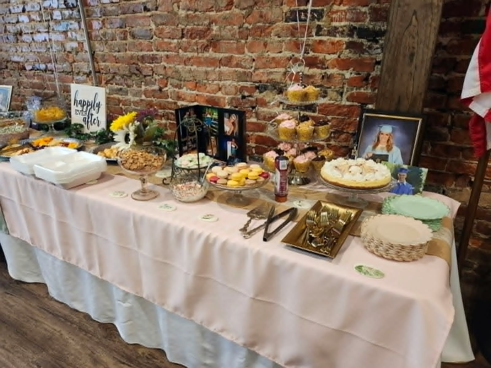 Wide view of a graduation dessert buffet with cupcakes and cookies