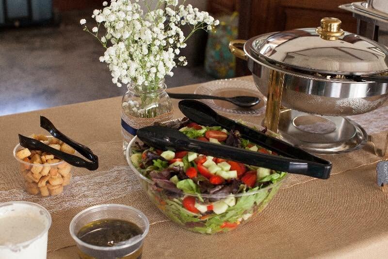 Buffet station with fresh salad, croutons, dressings, chafing dish, and baby’s breath