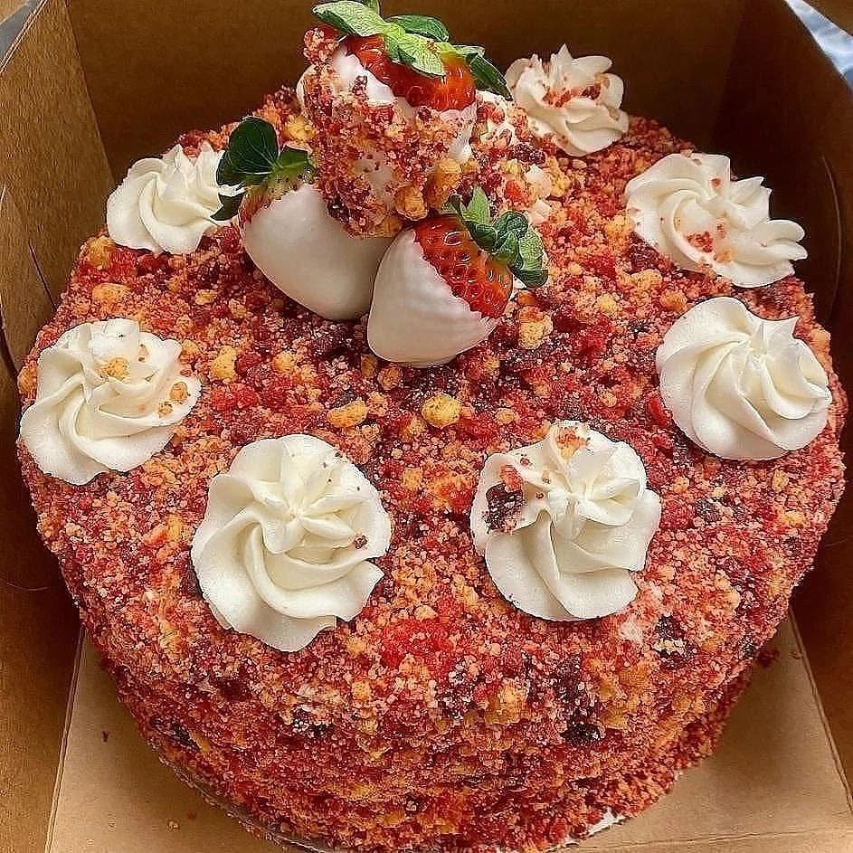 Strawberry crunch cake topped with fresh strawberries and white rosettes