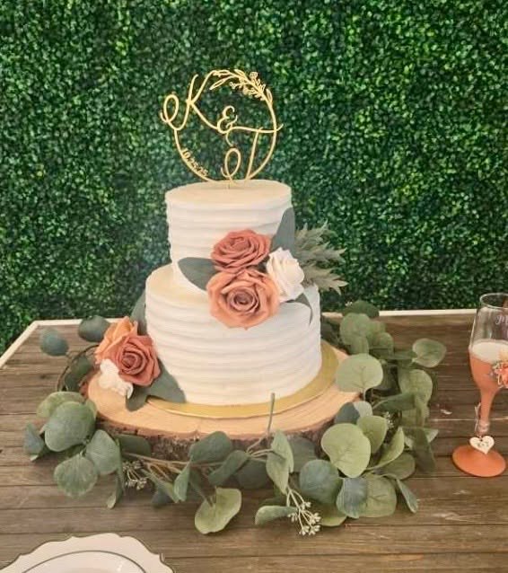 Two-tier wedding cake with dusty rose flowers and eucalyptus greenery